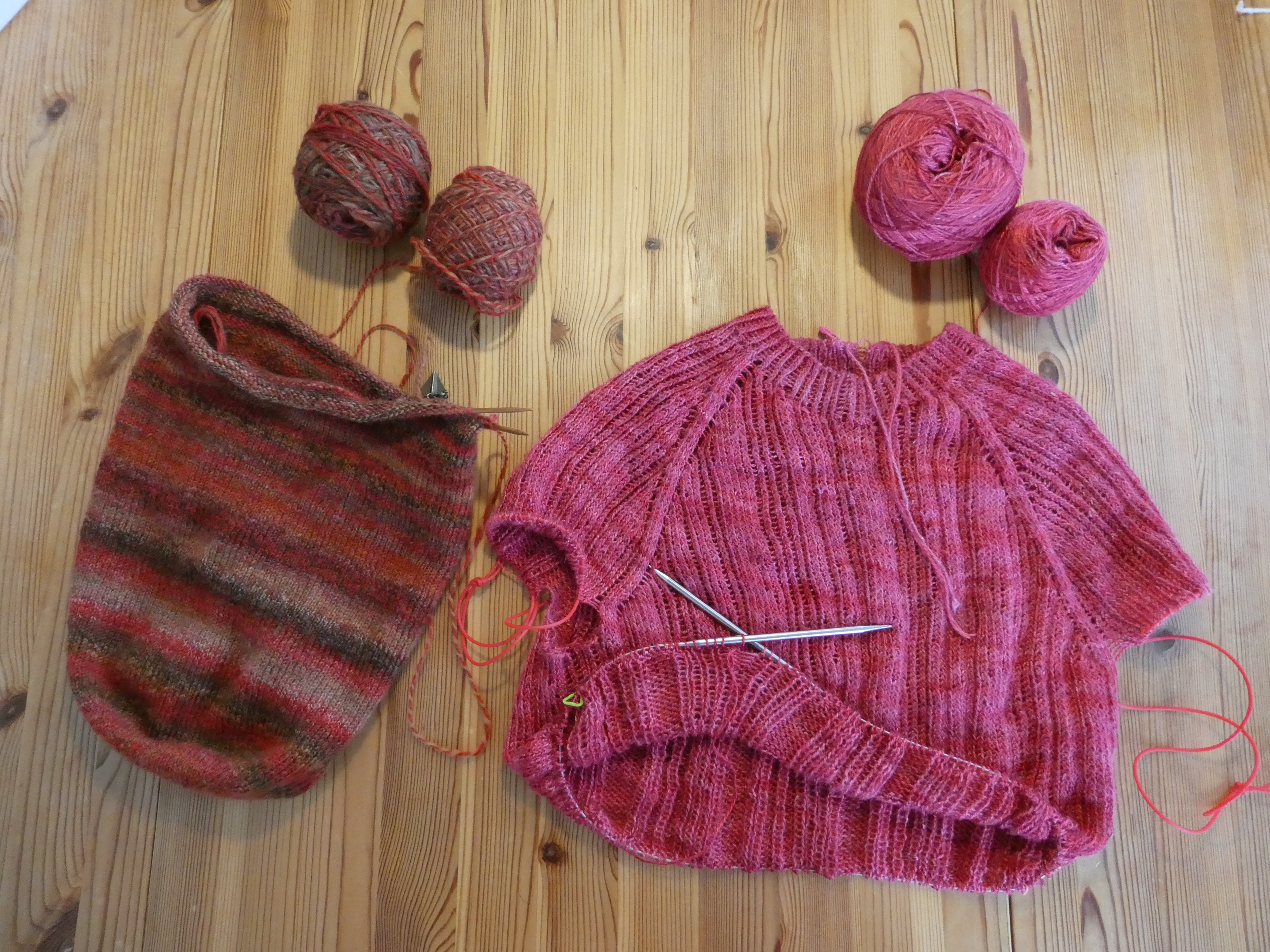 on the left: an unfinished hat in handspun, on the right: an unfinished top with a twisted rib pattern in fine silk yarn
