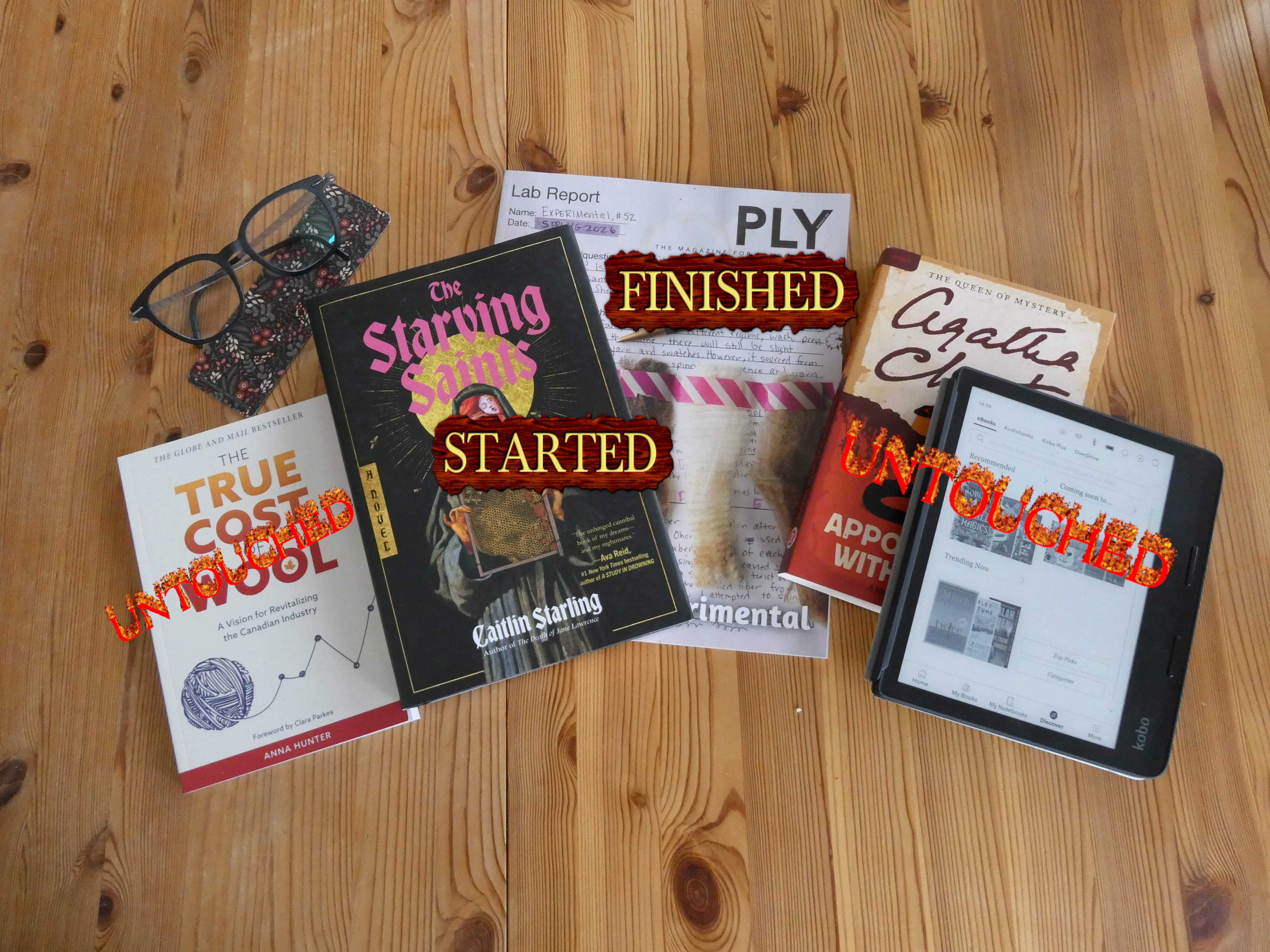 books from left to right: the true cost of wool (untouched), the starving saints (started), 52nd edition of ply magazine (finished), appointment with death by agatha christie (untouched), my kobo (untouched)